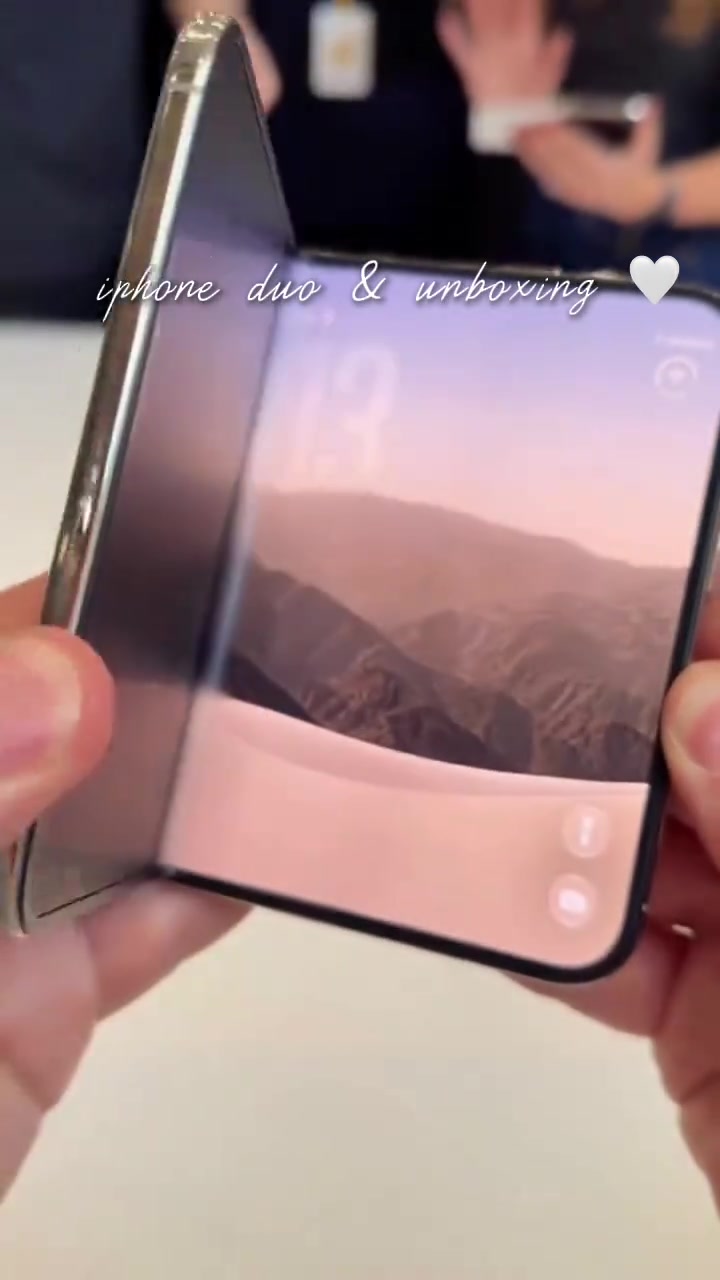 iPhone Duo dibuka separuh di tangan pembeli, skrin lipat dan lipatan tengah kelihatan jelas