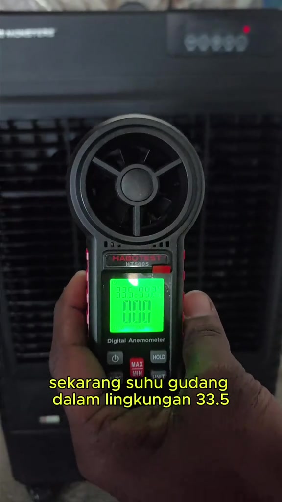 Anemometer digital di depan air cooler hitam menunjukkan suhu gudang sekitar 33.5 darjah Celsius sebelum ujian