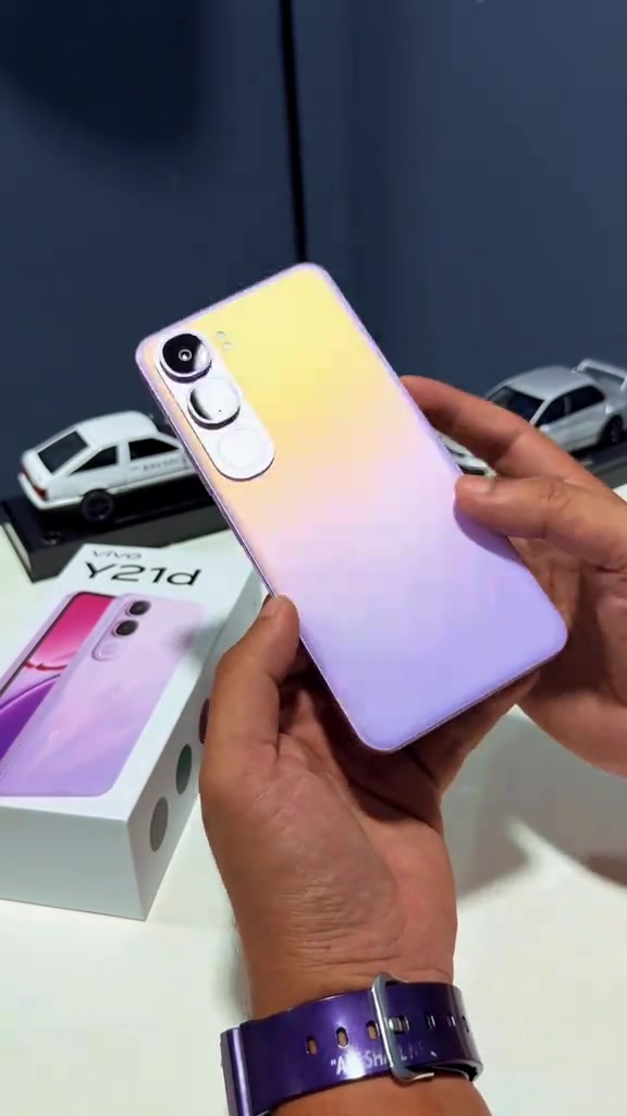 Badan belakang vivo Y21d warna ungu pudar dipegang dari sudut condong, modul dua kamera dan flash kelihatan jelas
