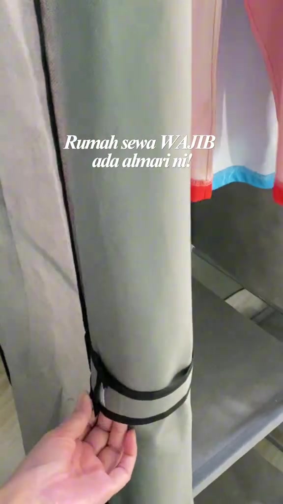 Tangan menggulung dan mengikat pintu kain almari zip ke tiang rangka, menunjukkan pintu fabrik boleh digulung ke atas