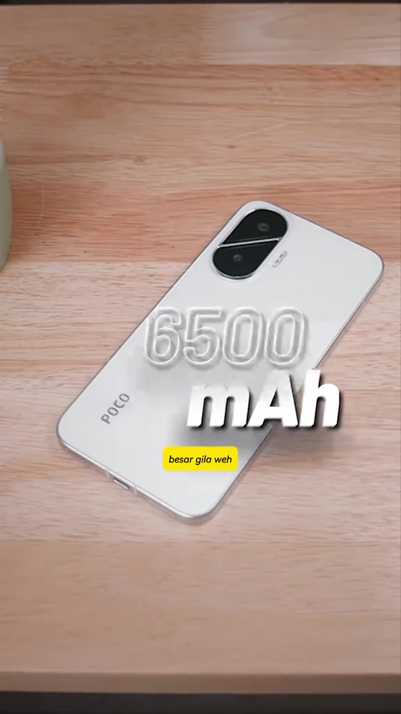 POCO F7 warna putih dibaringkan atas meja kayu dengan teks 6500 mAh pada gambar