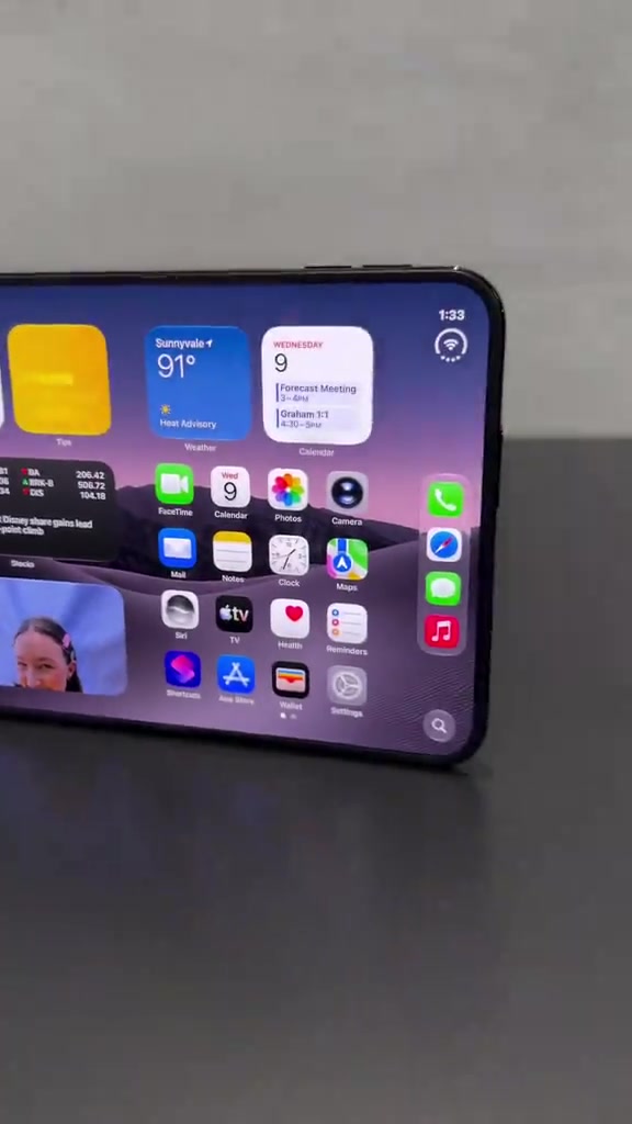 Skrin dalam 7.6 inci iPhone Duo berdiri di atas meja memaparkan widget iOS