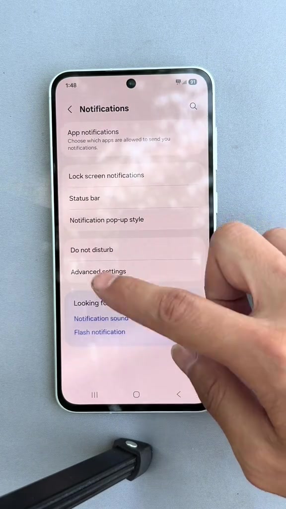 Jari menunjuk ke menu Notifications dalam tetapan telefon Samsung dengan pilihan App notifications, Lock screen notifications dan Do not disturb