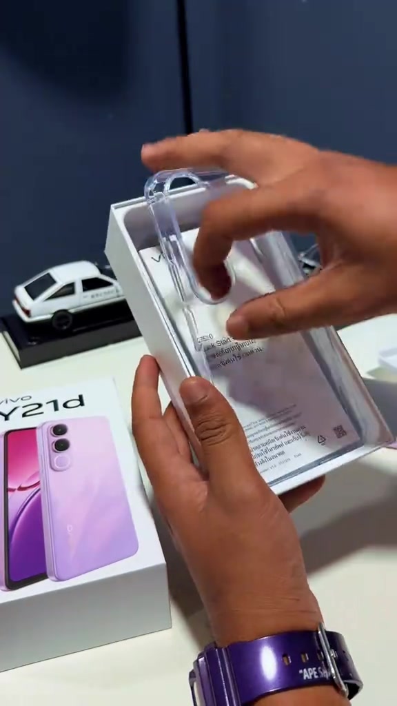 Kotak vivo Y21d dibuka, tangan mengeluarkan sarung telefon lutsinar daripada ruangan dalam kotak