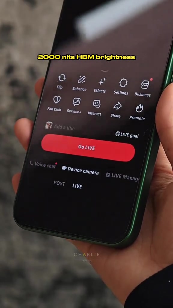 Skrin telefon papar butang Go LIVE pada aplikasi TikTok dipegang dengan satu tangan