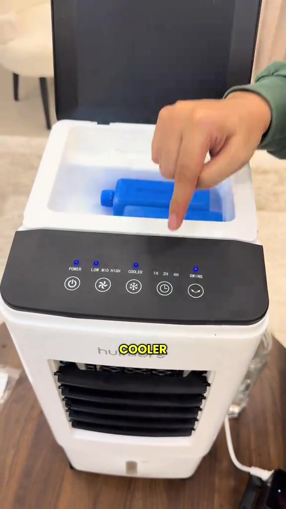 Jari tunjuk butang COOLER pada panel air cooler mini dengan ice pack biru dalam tangki