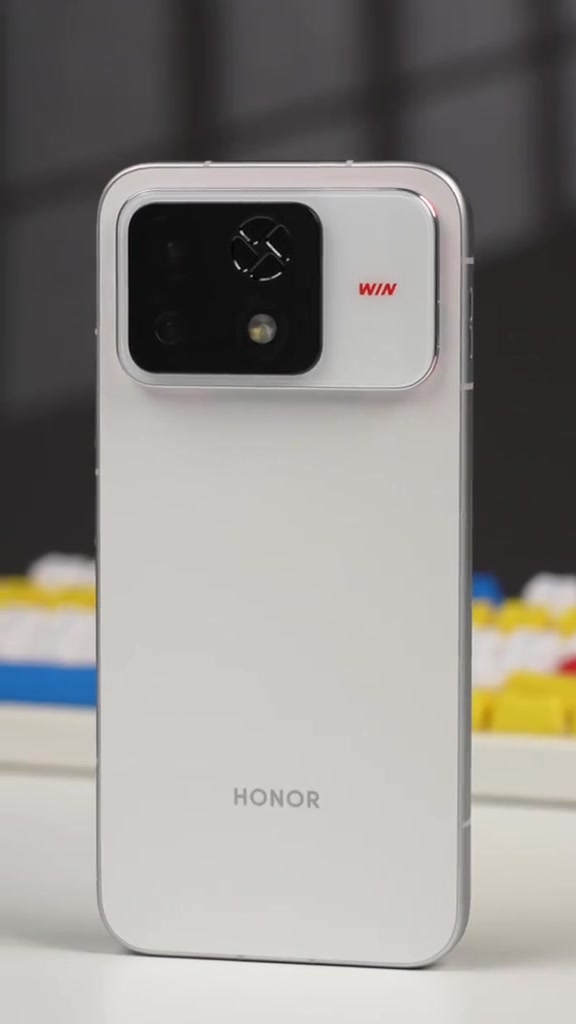 Mặt lưng Honor WIN 2 màu trắng dựng đứng, cụm camera kèm lưới quạt tròn và chữ WIN màu đỏ