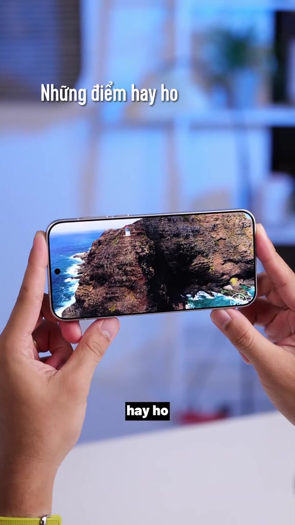 Hai tay cầm ngang chiếc OPPO Find X10 Pro Max màu trắng đang hiển thị ảnh vách đá ven biển trên màn hình