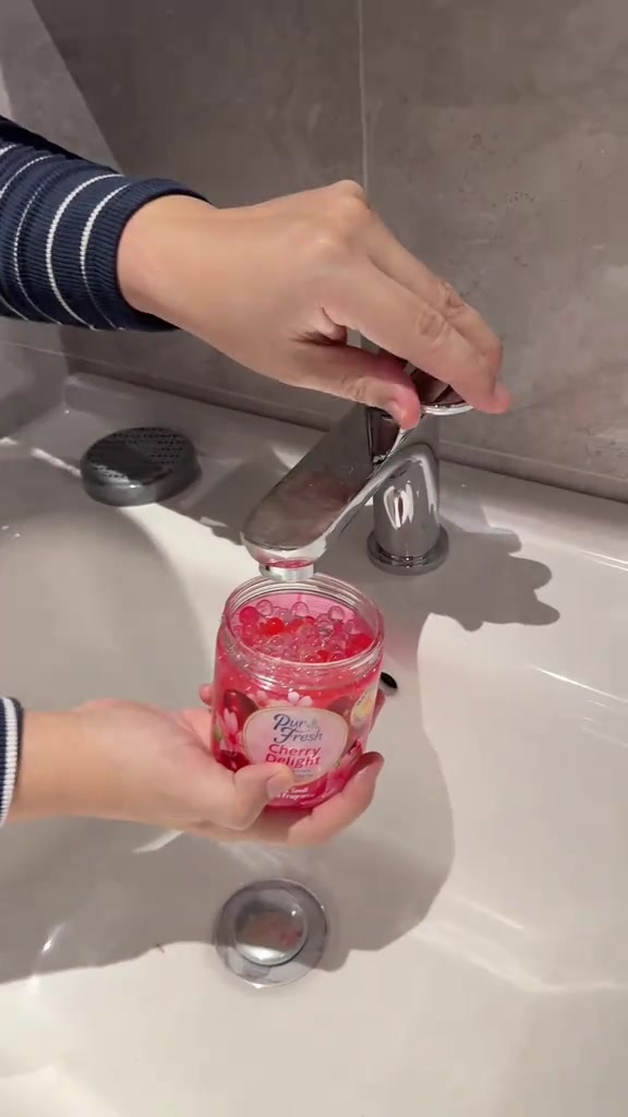 Tangan menambah air paip ke dalam balang beads Pur Fresh Cherry Delight di sinki