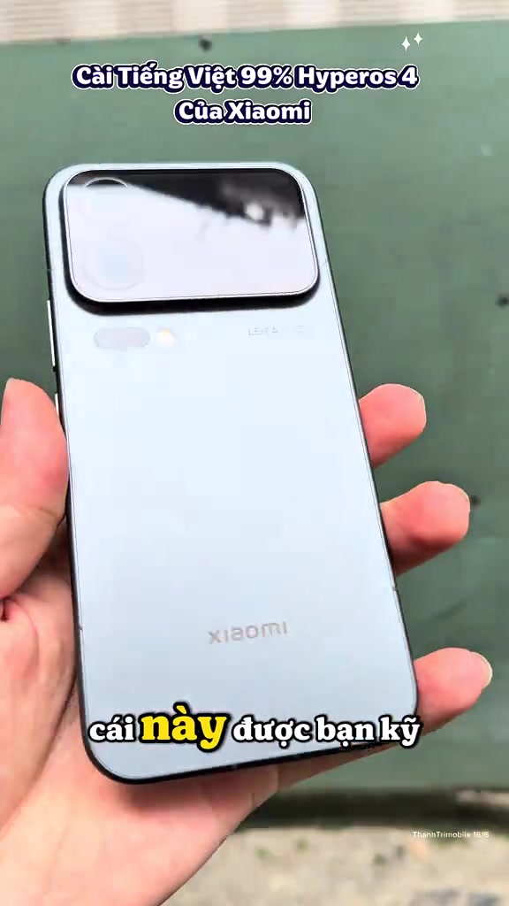Mặt lưng Xiaomi 18 Pro Max màu xanh nhạt cầm trên tay, cụm màn hình phụ nằm ngang phía trên và dòng chữ Leica