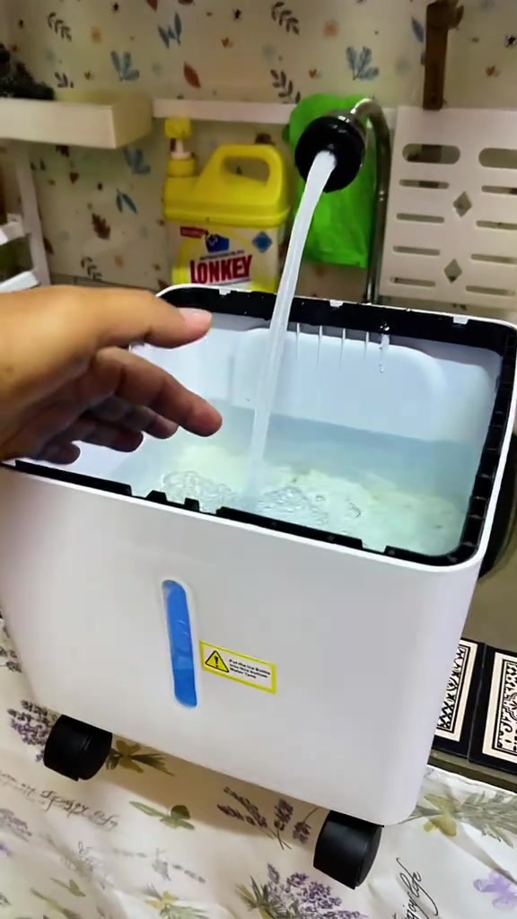 Tangan mengisi air paip ke dalam tangki air cooler yang boleh tanggal