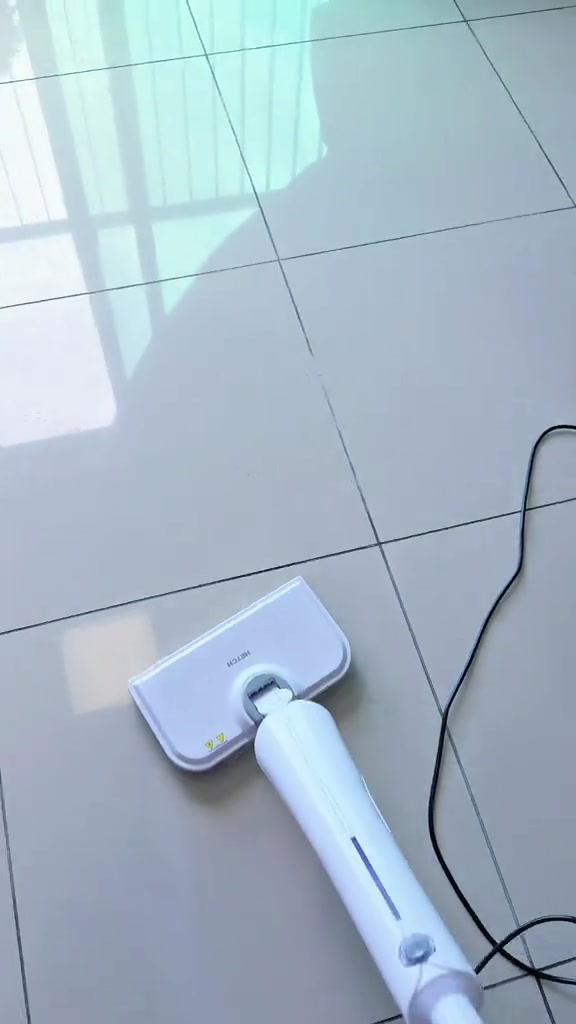 Steam mop putih di atas lantai jubin berkilat yang baru dibersihkan, wap nipis masih kelihatan