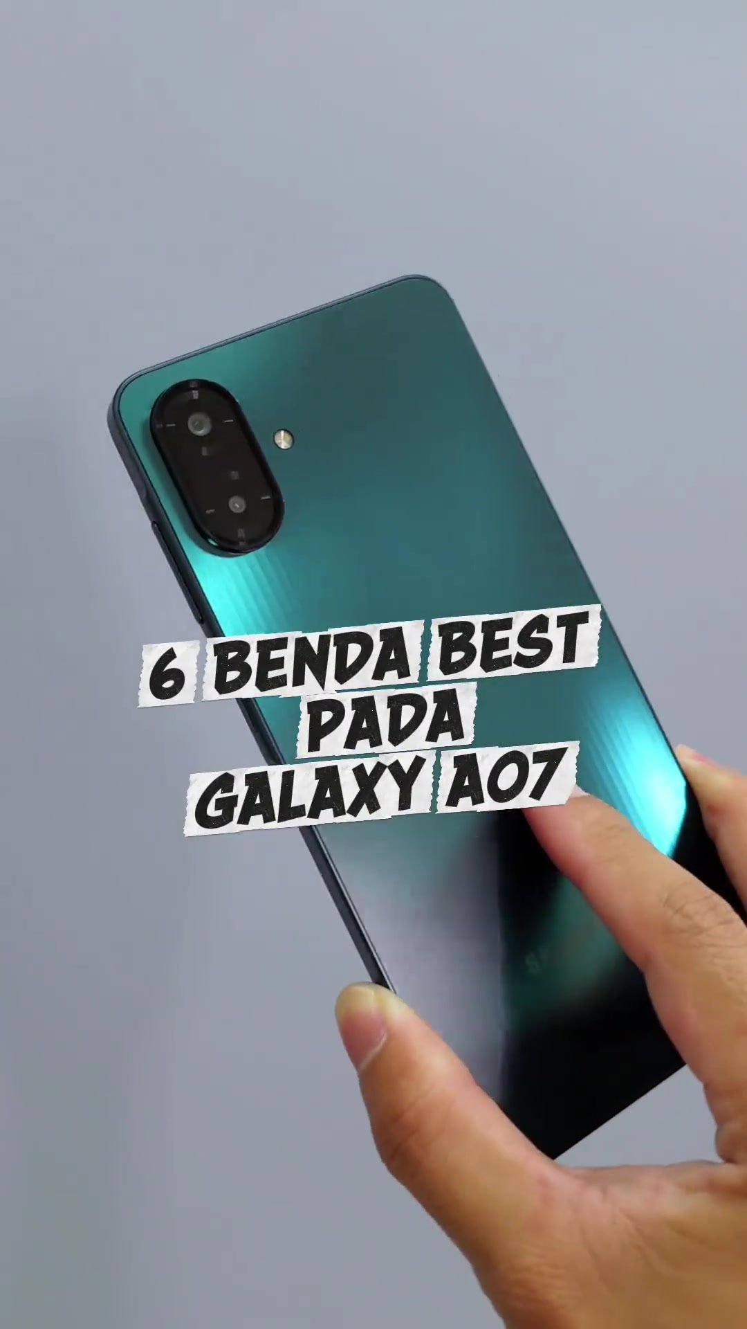 Belakang Samsung Galaxy A07 warna hijau teal dengan modul kamera dua lensa, dipegang sebelah tangan