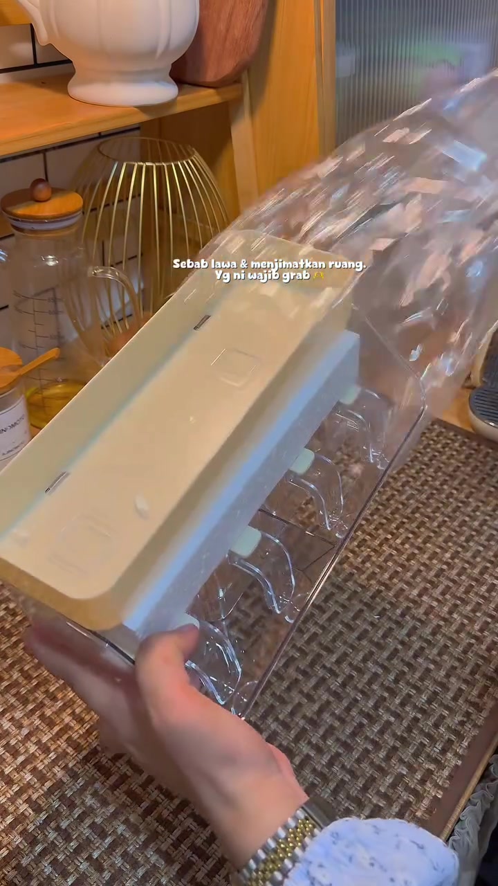 Bekas acrylic transparan dengan empat bekas rempah kecil berpenutup dan tray atas krim, dipegang tangan
