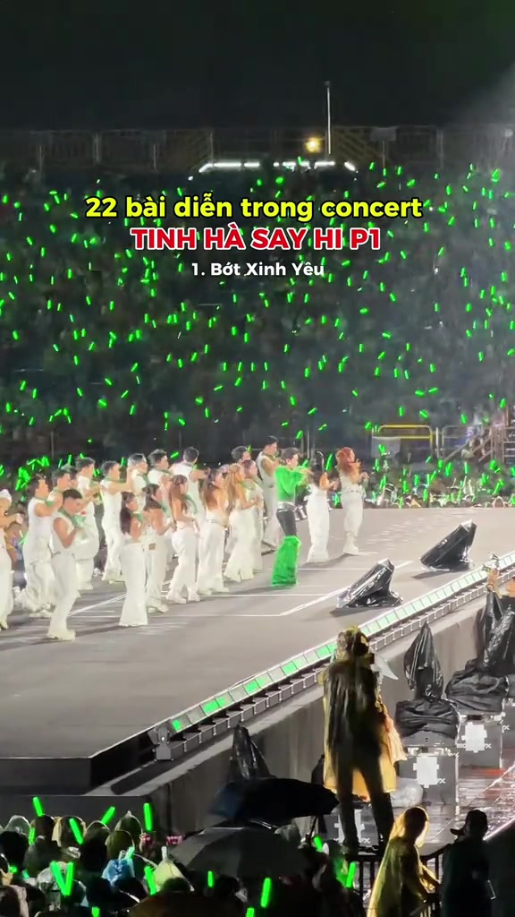 Sân khấu chính concert Tinh Hà Say Hi nhìn từ khán đài với dàn nghệ sĩ trang phục trắng và biển lightstick màu xanh lá của khán giả