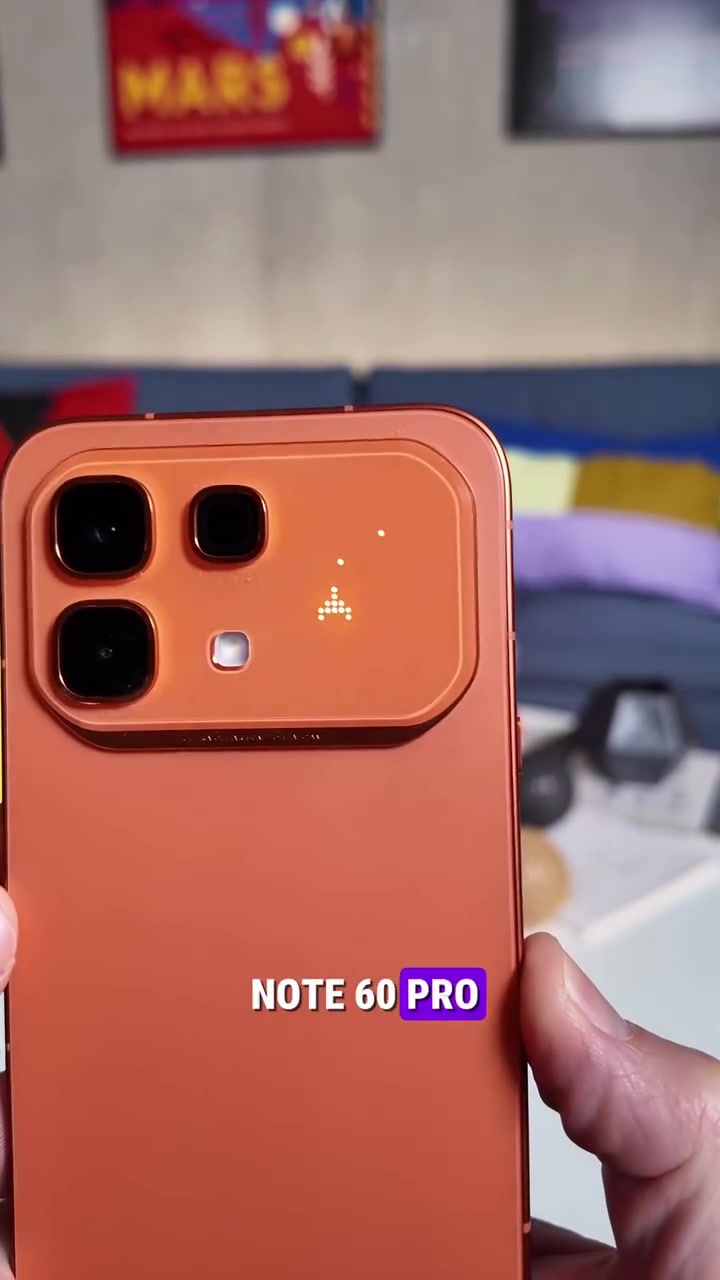 Bahagian belakang Infinix NOTE 60 Pro warna oren dengan paparan Active Matrix menyala menunjukkan ikon pixel pada pulau kamera