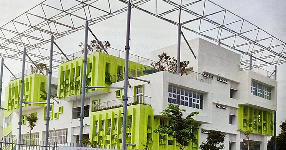 Mặt tiền Trung tâm Văn hóa Hòa Bình với khối nhà trắng điểm mảng xanh lá và khung thép mái, nơi đặt sân khấu C30