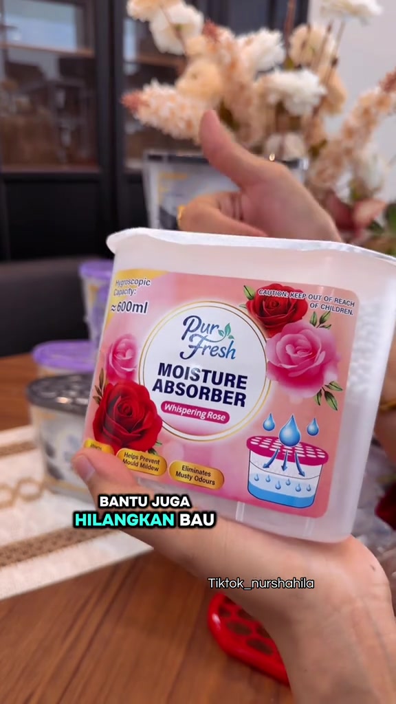 Kotak serap air Pur Fresh terbuka dipegang dengan isyarat jari bagus di belakangnya