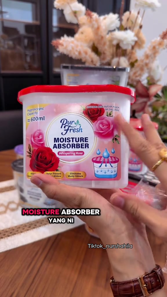 Tangan memegang kotak serap air Pur Fresh 600ml berlabel Whispering Rose dengan kapasiti higroskopik 600ml