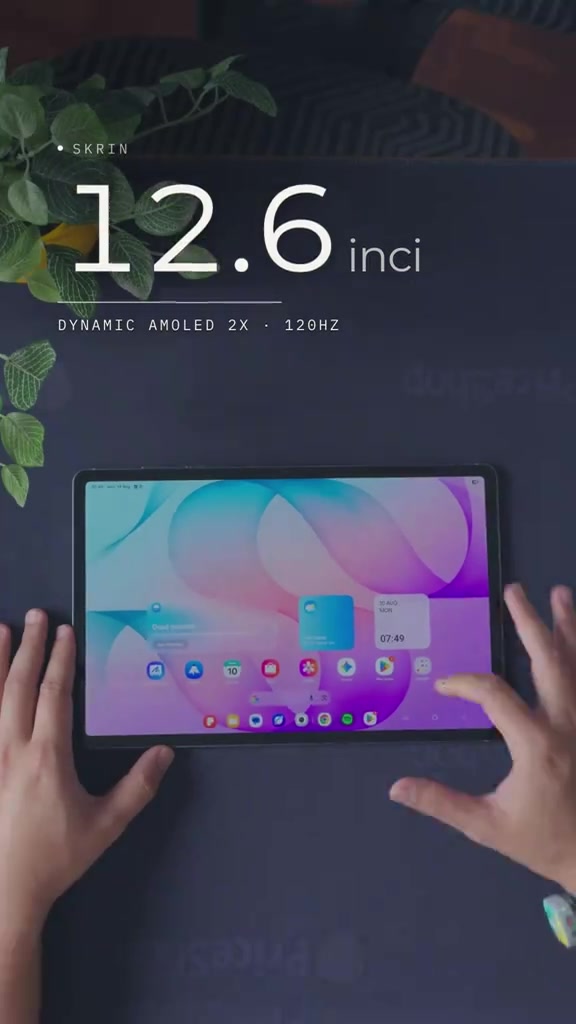 Galaxy Tab S12+ dilihat dari atas dengan skrin hidup dan tangan di kedua-dua sisi, bertanda skrin 12.6 inci Dynamic AMOLED 2X 120Hz