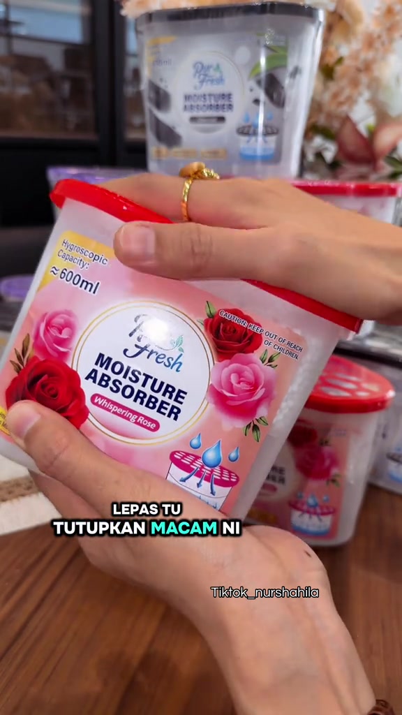 Tangan menutup penutup merah berlubang ke atas kotak serap air Pur Fresh selepas seal atas dibuka