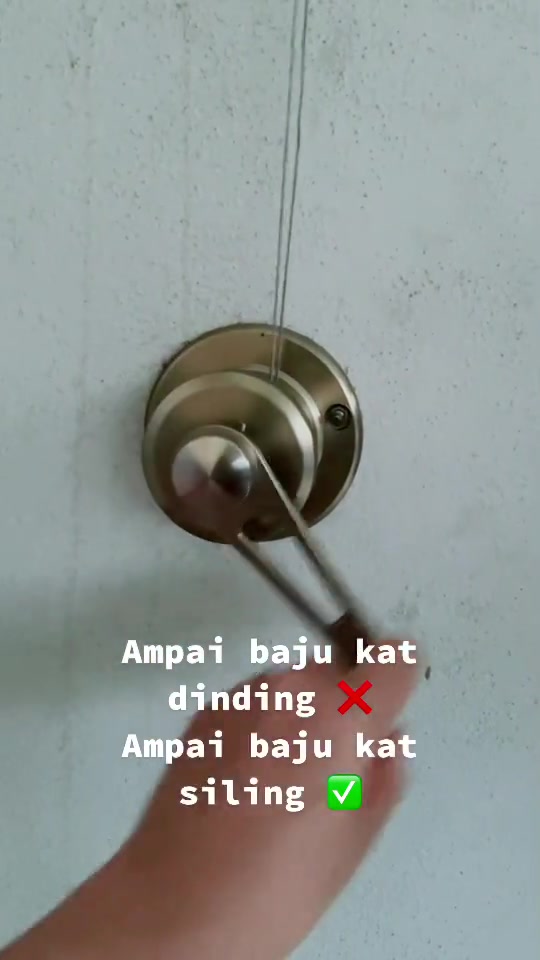 Winch pulley stainless dengan handle pemutar melekat pada dinding dengan kabel keluli menghala ke atas