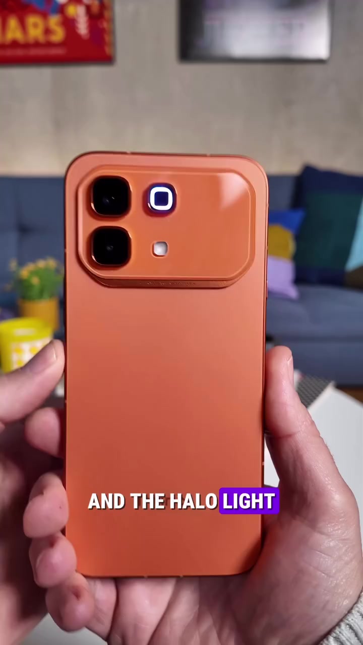 Belakang Infinix NOTE 60 Pro warna oren dipegang dengan dua tangan, cincin halo light menyala pada pulau kamera