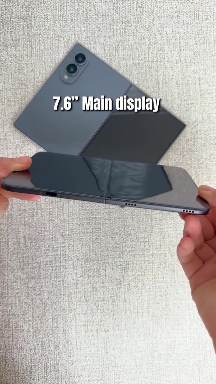 Màn hình trong của iPhone Duo mở phẳng soi thấy vệt nếp gấp chạy giữa màn, phía sau là một máy gập màu xám