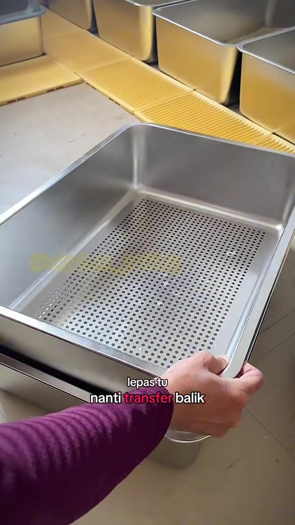 Dulang penapis stainless steel berlubang halus diangkat dari atas dulang bawah semasa proses sifting pasir kucing