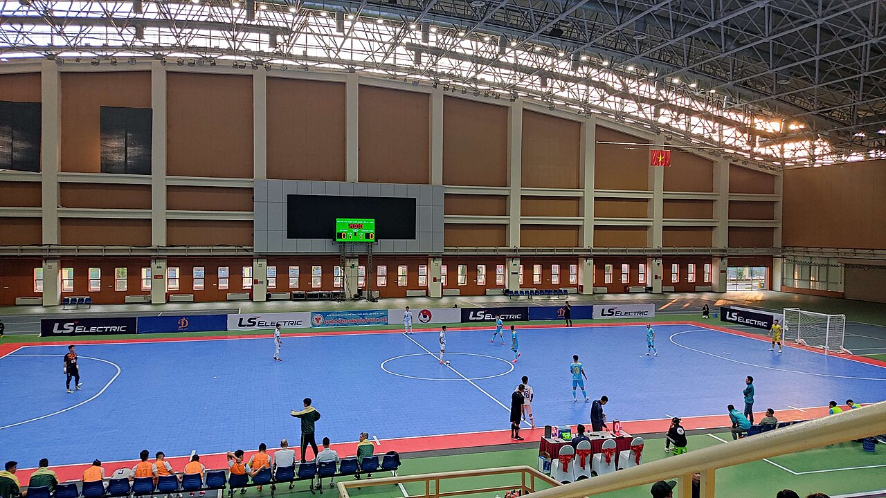 Không gian bên trong Cung thi đấu điền kinh trong nhà Mỹ Đình với khán đài bao quanh và mặt sàn thi đấu rộng