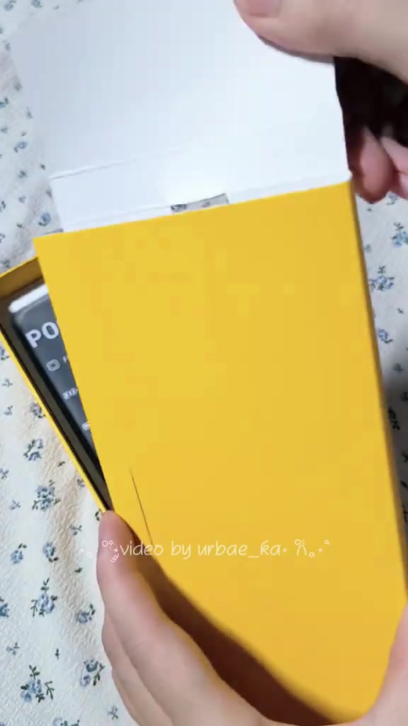 Tay đang mở hộp POCO X8 Pro với vỏ hộp màu vàng đặc trưng của POCO