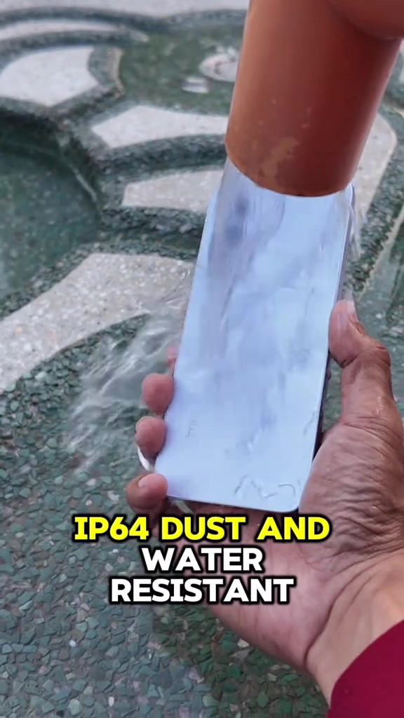 Telefon realme berwarna putih sedang dicondongkan sambil air dicurahkan ke atas badannya sebagai ujian rintangan air IP64