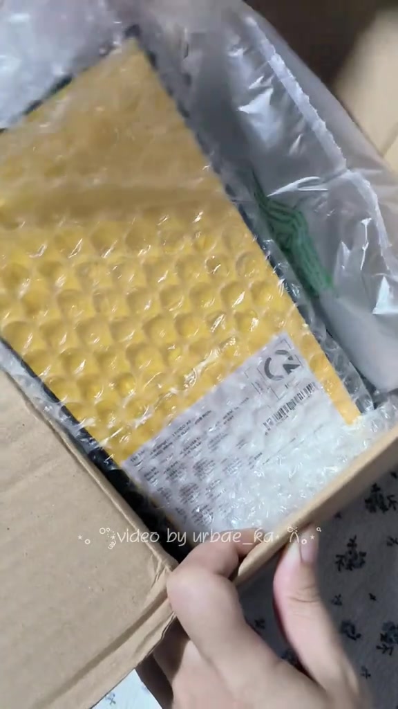 Kiện hàng bọc chống sốc màu vàng nằm trong thùng carton, kiểu đơn điện thoại đặt online về đến nhà