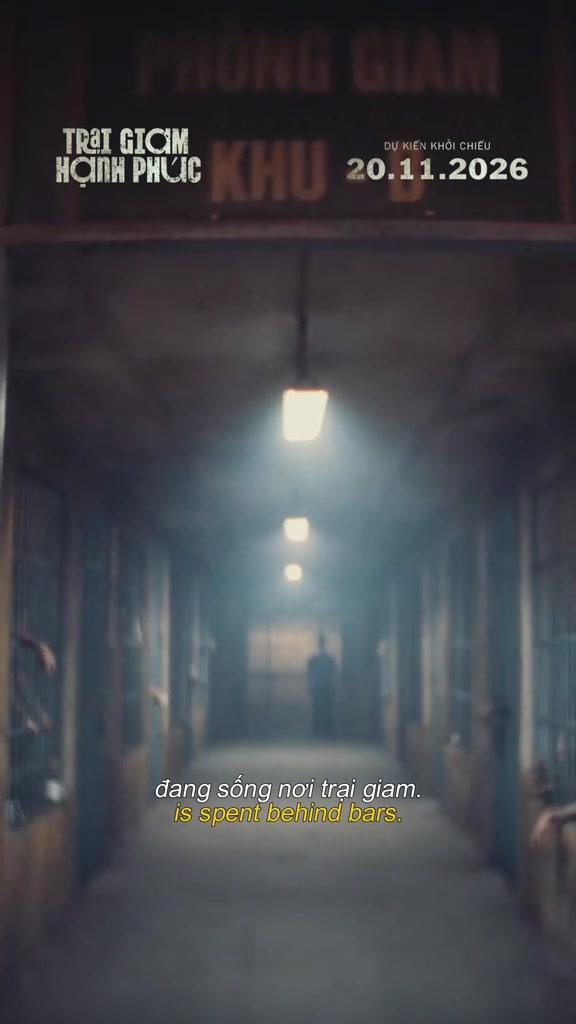 Hành lang trại giam tối với dãy đèn trần và bóng người đứng khuất ở cuối hành lang, khuôn hình từ first look chính thức của phim Trại Giam Hạnh Phúc