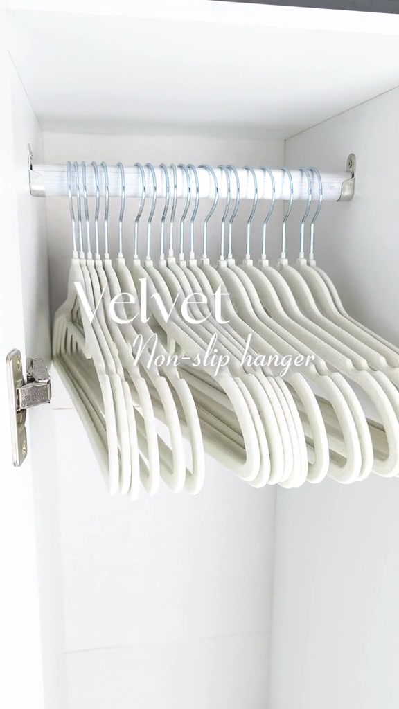 Hanger velvet warna cerah tergantung rapi pada rail logam dalam almari putih