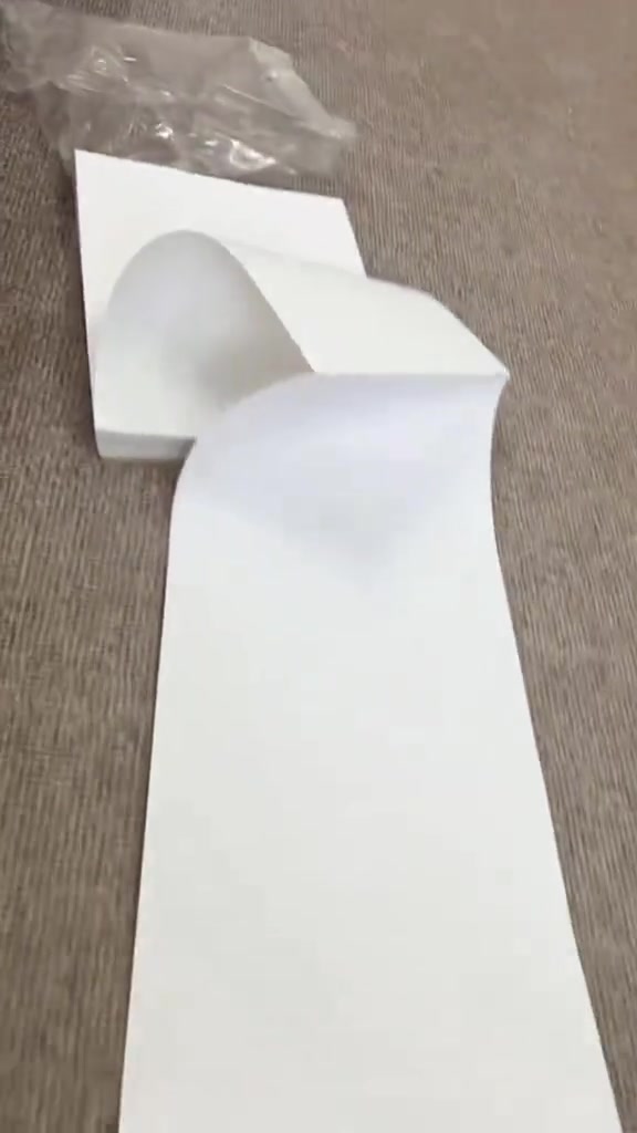 Roll kertas thermal A4 berwarna putih terurai di atas lantai