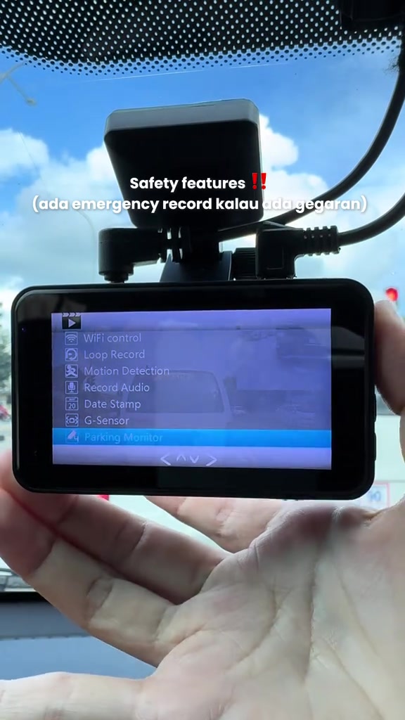 Dashcam berskrin di tangan menunjukkan menu tetapan: WiFi control, Loop Record, Motion Detection, Record Audio, Date Stamp, G-Sensor dan Parking Monitor