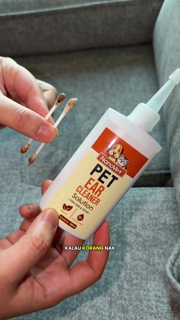 Dua cotton bud berkotoran coklat dipegang di sebelah botol NanoVet Pet Ear Cleaner Solution 150ml
