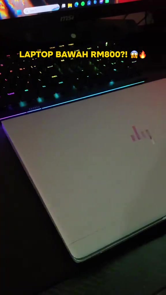 Tutup laptop HP EliteBook warna perak di atas meja dengan papan kekunci RGB di latar