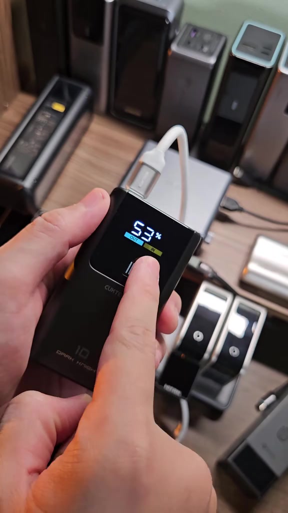 Cận cảnh màn hình CUKTECH 10 mini hiện 53% pin cùng vạch công suất OUT và IN, ngón tay đặt lên nút nguồn