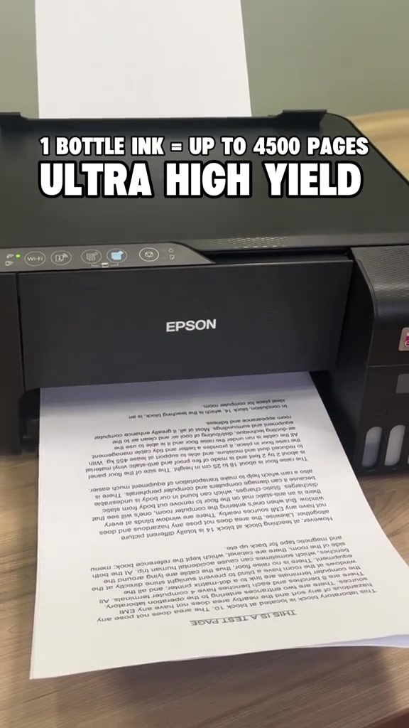 Printer Epson EcoTank berwarna hitam sedang mencetak helaian ujian penuh teks