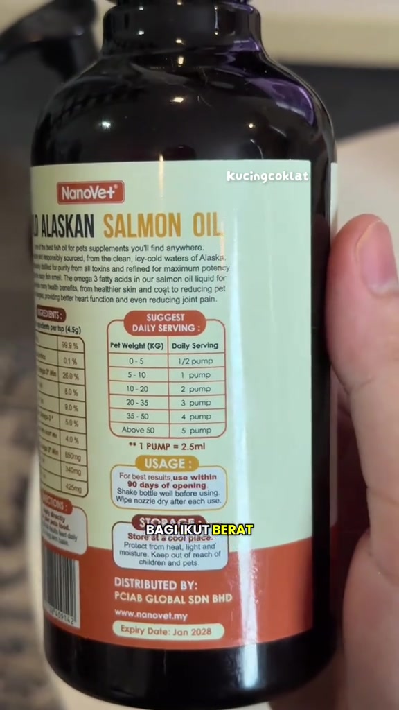 Label botol minyak salmon menunjukkan jadual dos harian ikut berat binatang dan nota satu pam bersamaan 2.5 ml