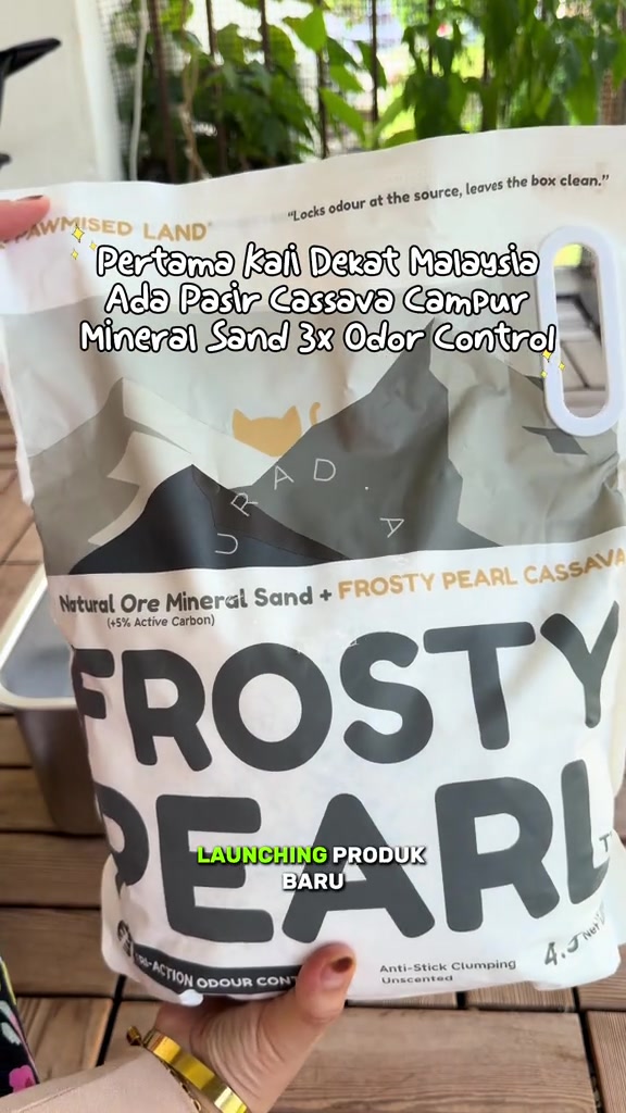 Tangan memegang beg Frosty Pearl berlabel Natural Ore Mineral Sand + Frosty Pearl Cassava dengan 5% arang aktif