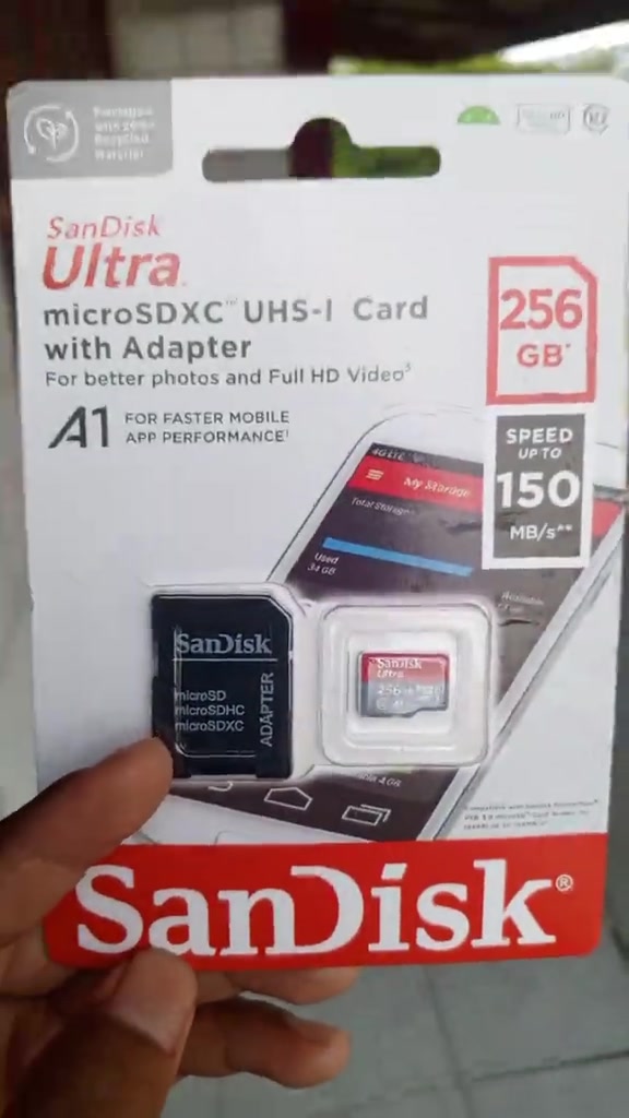 Pek kad SanDisk Ultra microSDXC 256GB dengan adapter dipegang di tangan