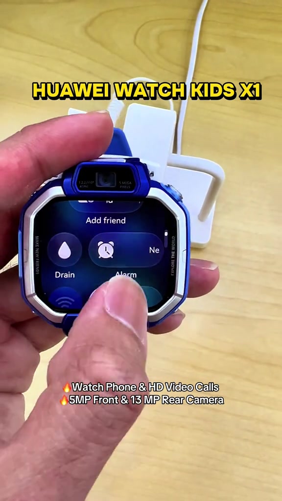 HUAWEI Watch Kids X1 biru di tangan, skrin menu dengan kamera atas terangkat