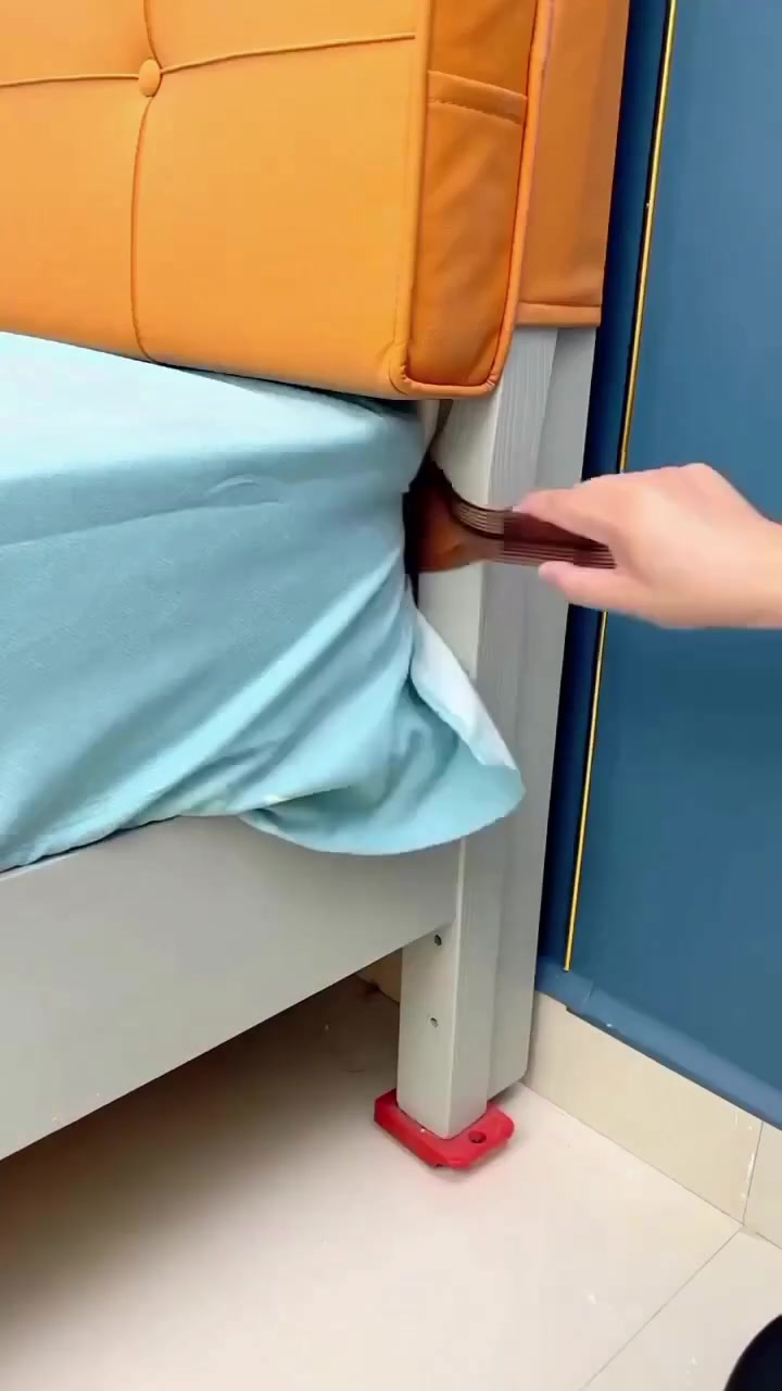 Alat bed sheet tucker warna ambar menolak cadar biru di penjuru katil berhampiran headboard