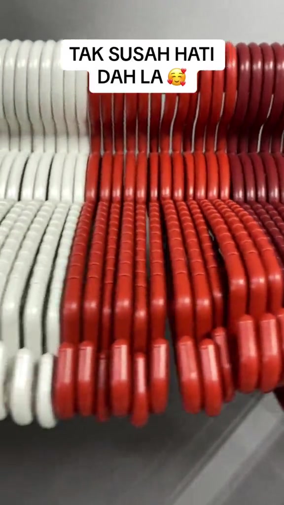 Deretan hanger plastik tebal warna putih dan merah disusun rapat sebelah-menyebelah