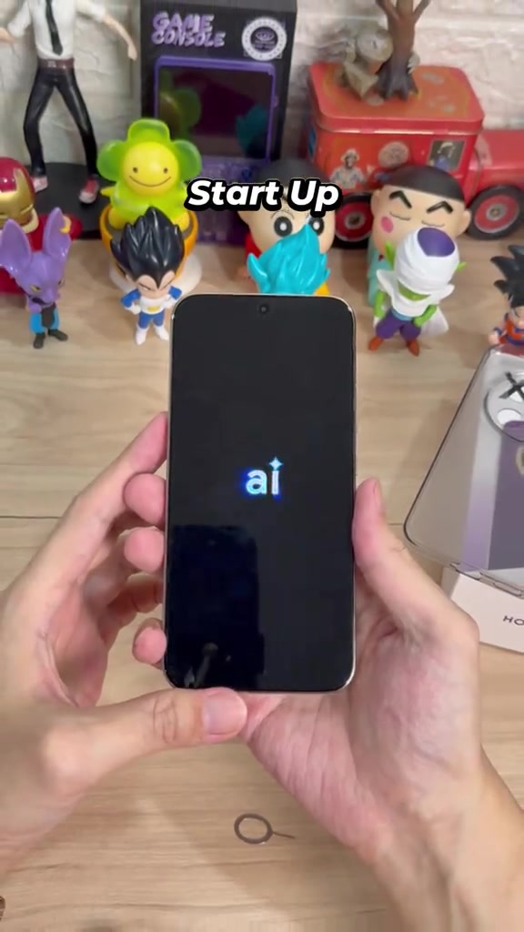 HONOR X9e Pro dipegang dua tangan dengan skrin sedang boot, kotak ritel kelihatan di sebelah