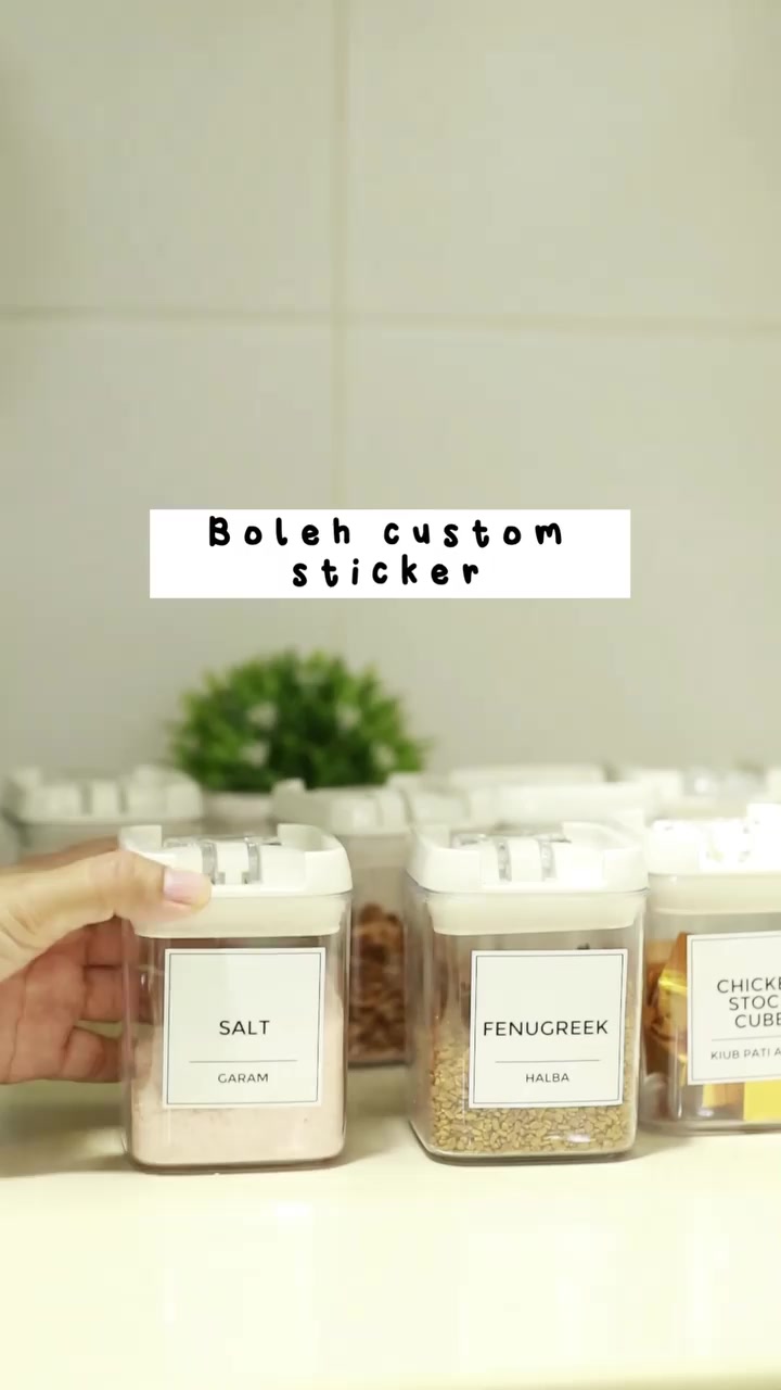 Barisan balang rempah transparan berlabel SALT, FENUGREEK dan chicken stock cube dengan penutup putih