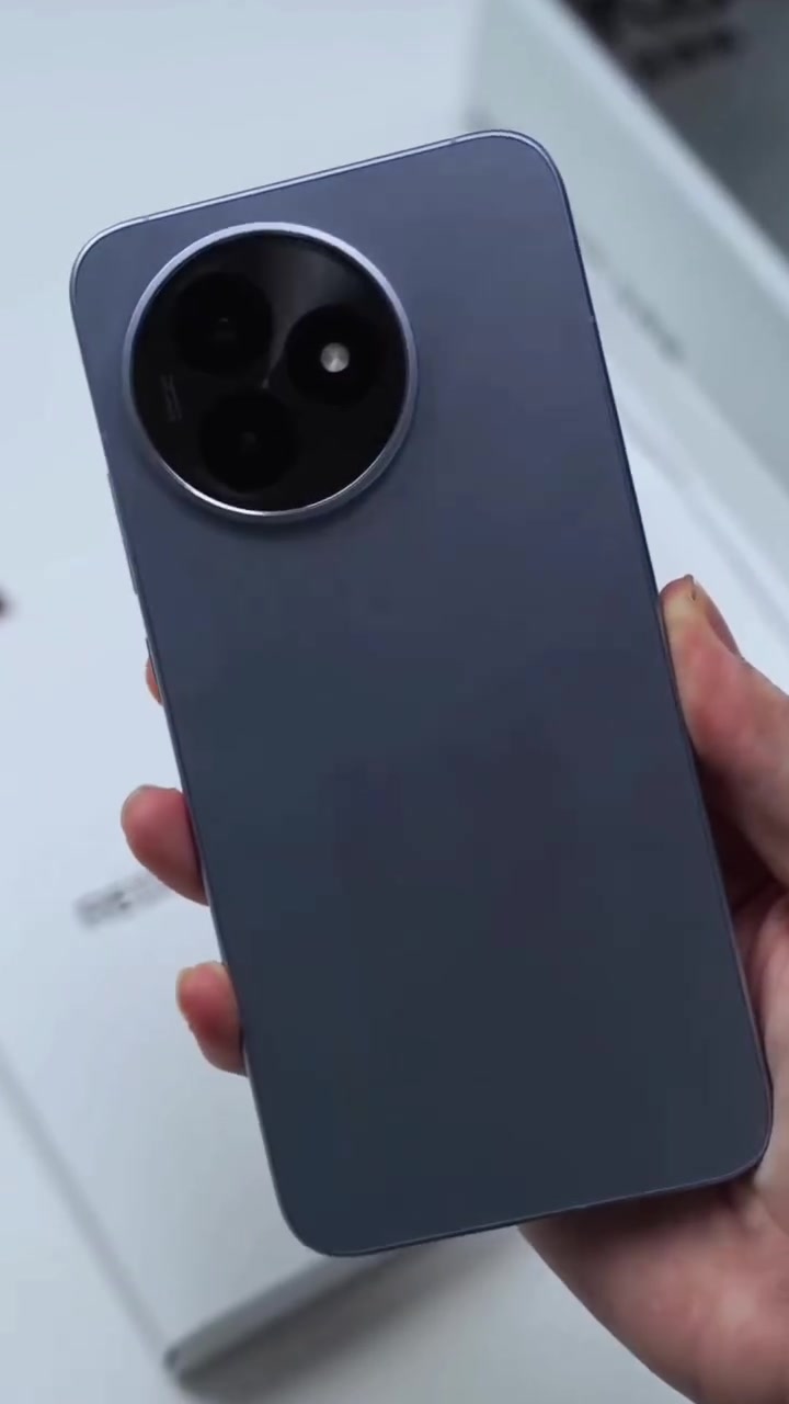 Mặt lưng màu xanh xám của Redmi K80 Ultra với cụm camera tròn ba ống kính viền kim loại, cầm trên tay